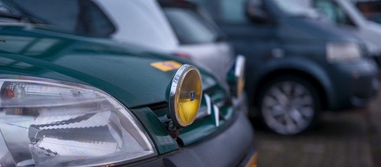 Afbeelding van een geparkeerde auto met gele verstralers.
