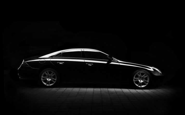 Afbeelding van een zwarte Mercedes Sedan met een zwarte achtergrond
