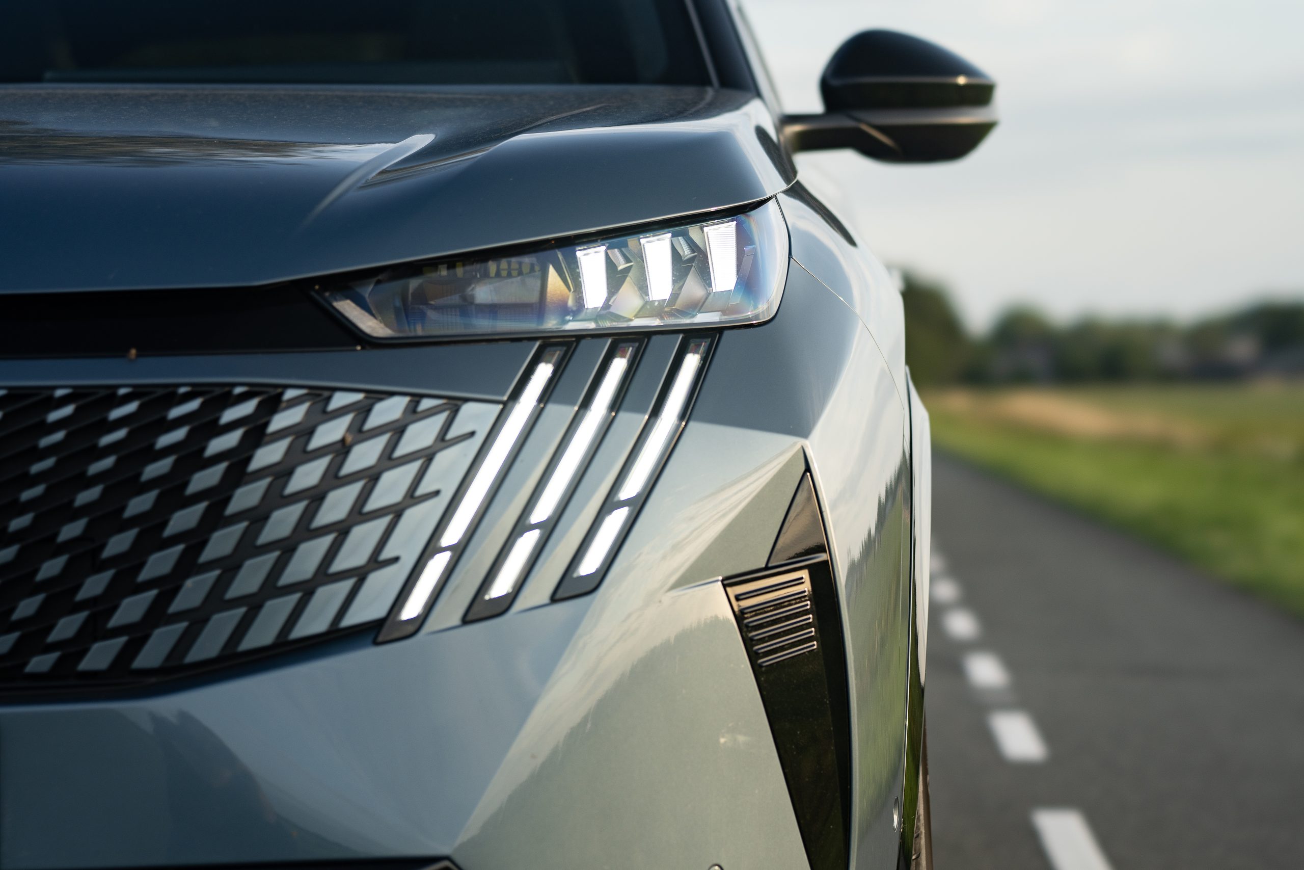 Afbeelding van de voorkant van de auto. Waarbij de koplamp duidelijk zichtbaar is.