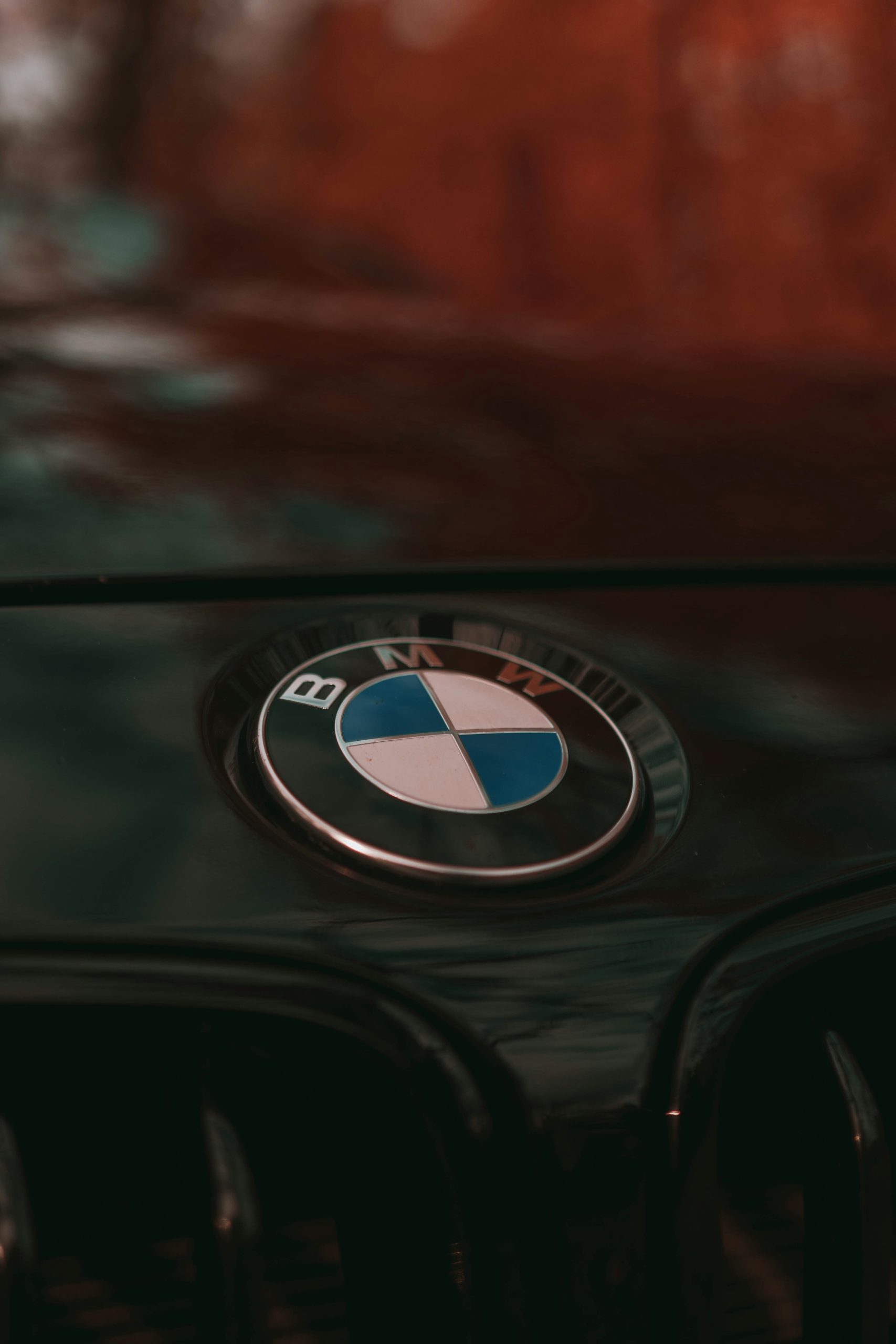 Detailfoto van het BMW lopgo op de motorkap van en zwarte auto.