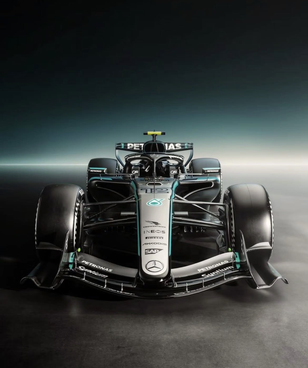 Een frontale close‑up van een Mercedes‑AMG Petronas F1‑auto met nummer 12, zwarte en turquoise livery en zichtbare sponsorlogo’s op neus en voorvleugel.