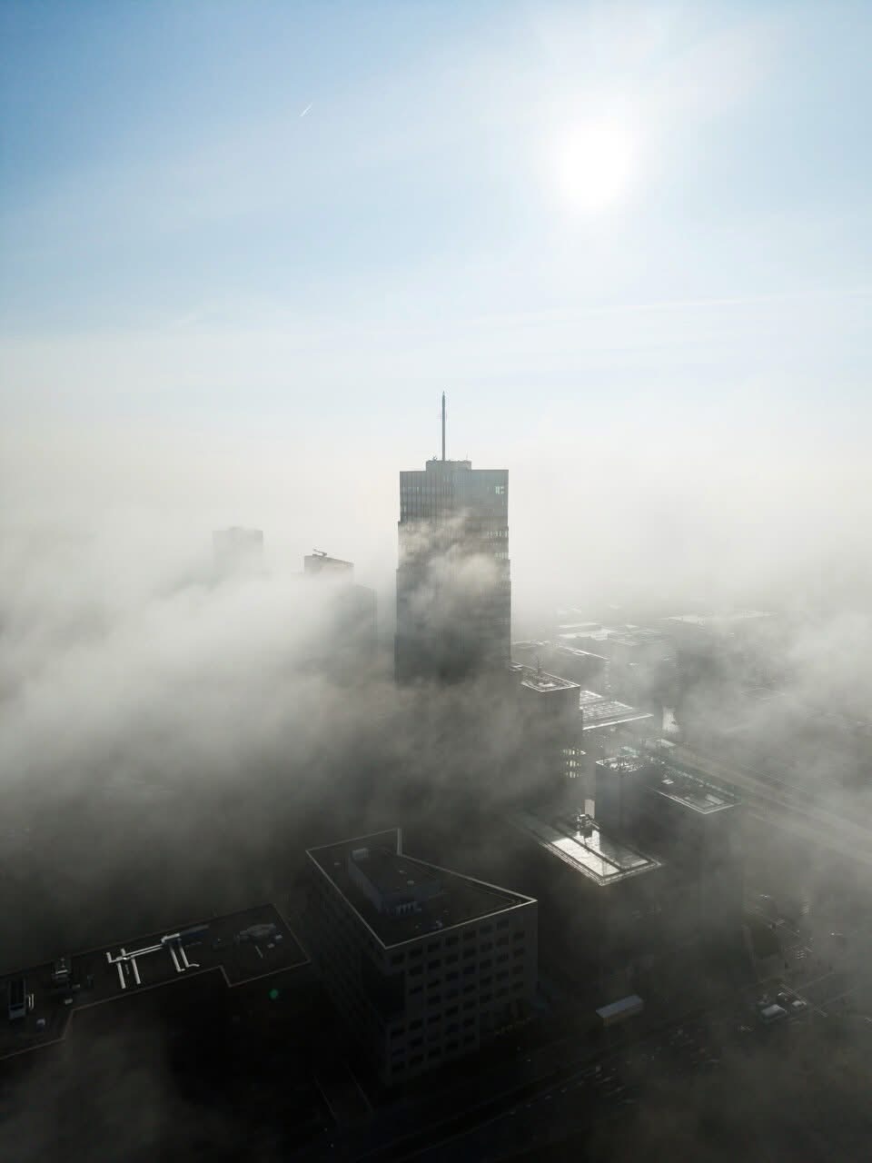 Wolkenkrabber boven de mist in de stad.