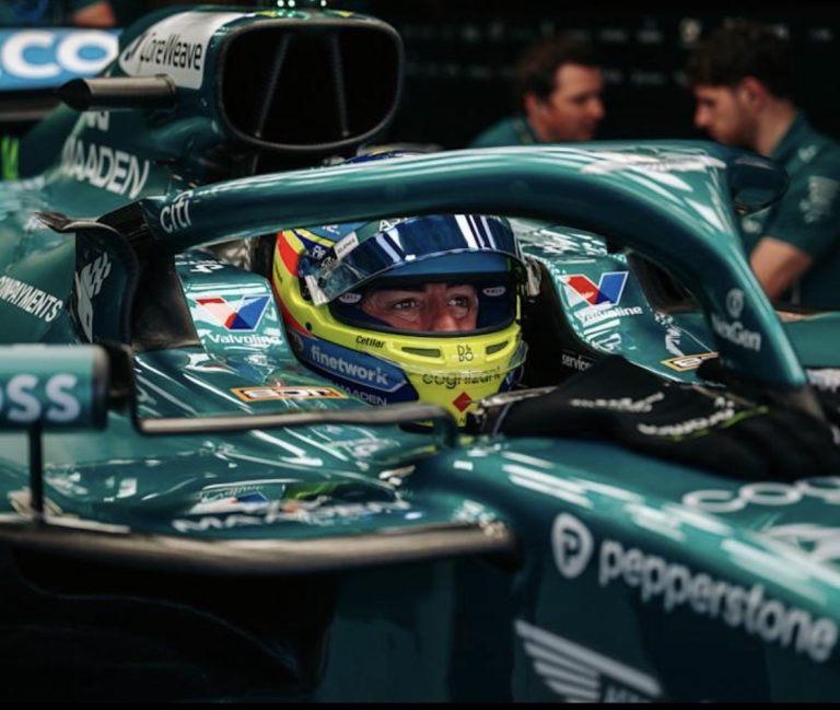 Fernando Alonso in zijn Aston Martin F1-auto met helm op.