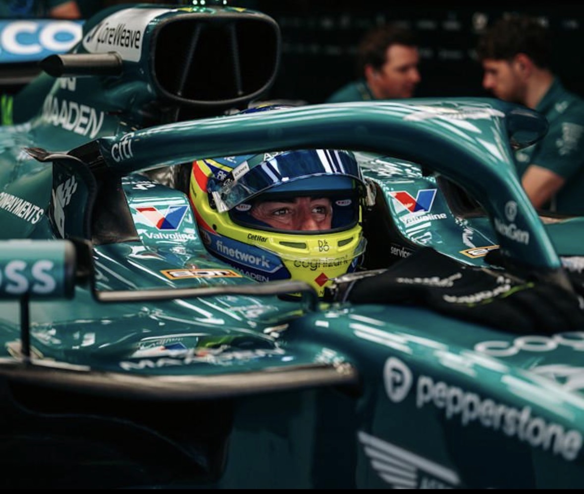 Fernando Alonso in zijn Aston Martin F1-auto met helm op.