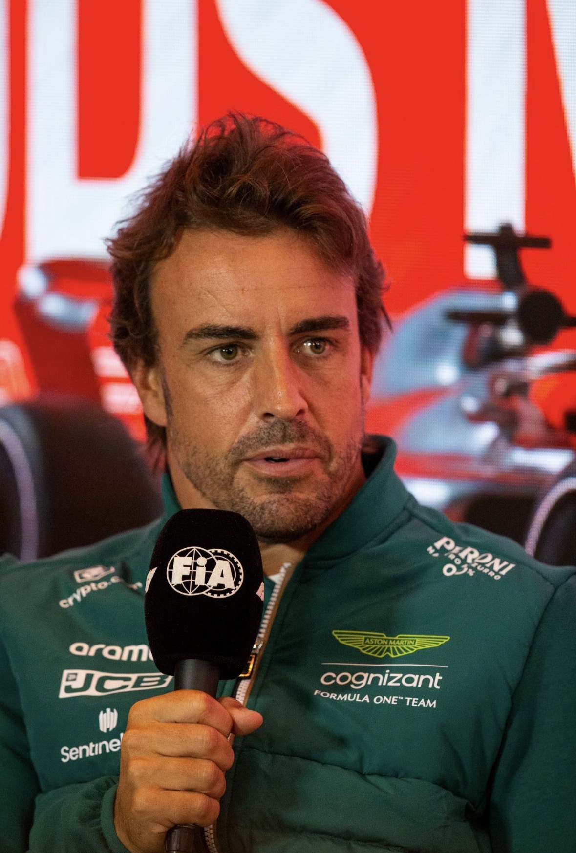 Fernando Alonso in Aston Martin jack spreekt in een FIA-microfoon.