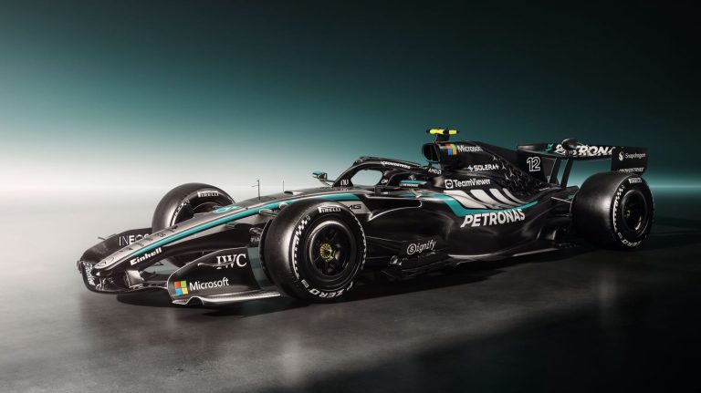 Zwarte Mercedes‑AMG Formule‑1‑auto met turquoise accenten en startnummer 12, scherp uitgelicht tegen een donkere studiobackground.