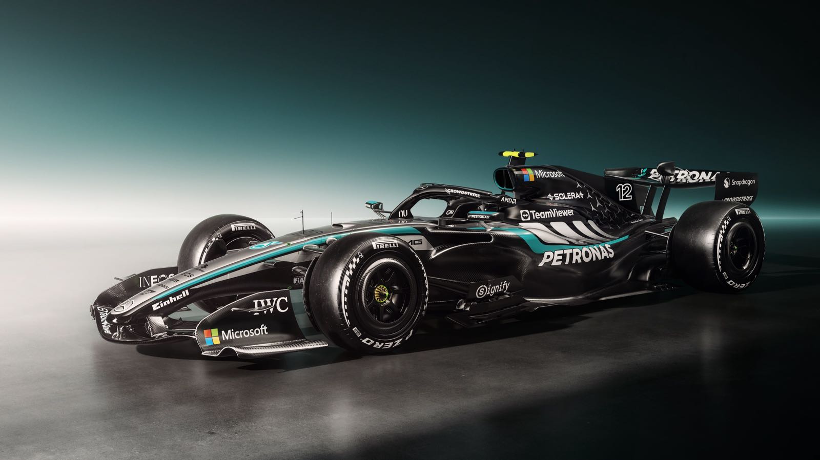 Zwarte Mercedes‑AMG Formule‑1‑auto met turquoise accenten en startnummer 12, scherp uitgelicht tegen een donkere studiobackground.