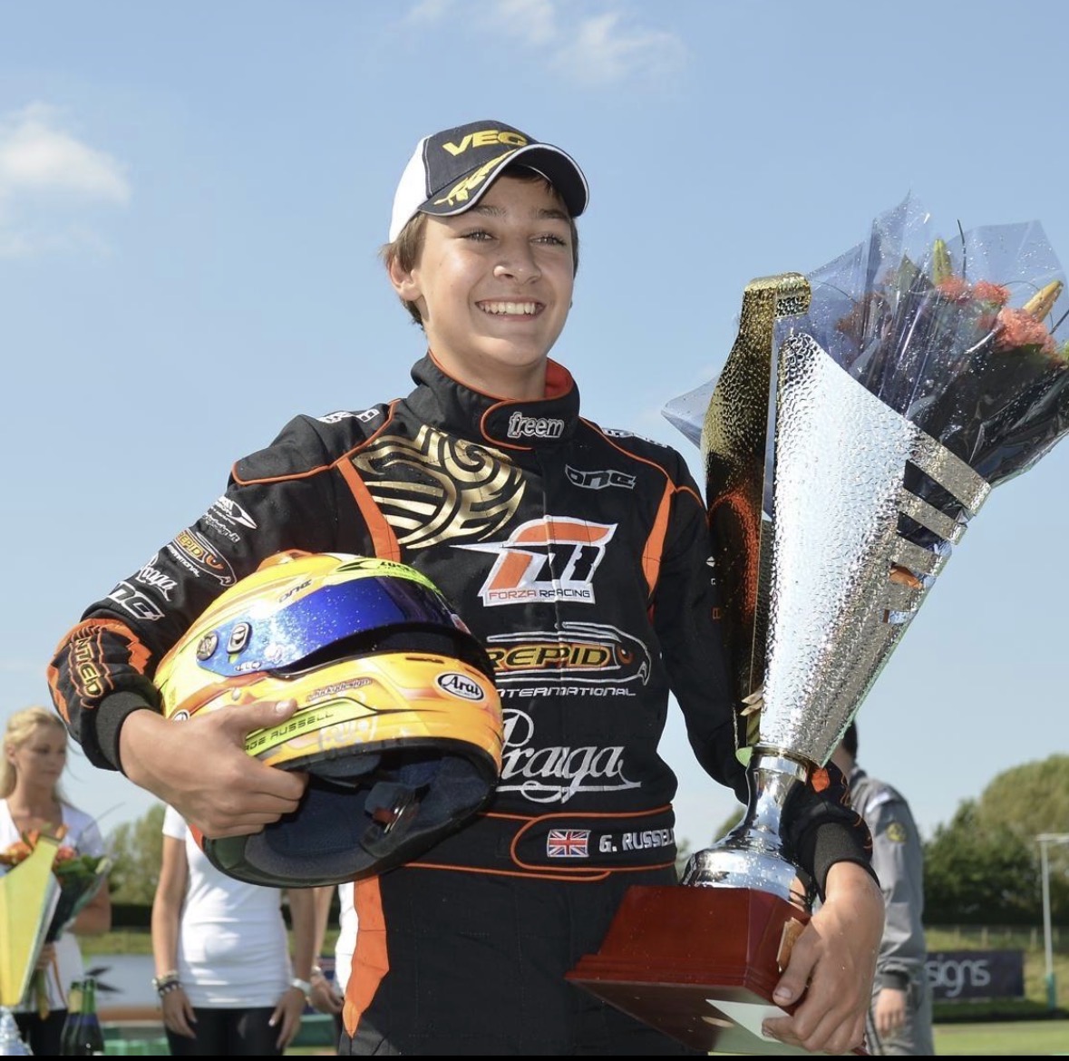 Jonge George Russell met trofee en helm.